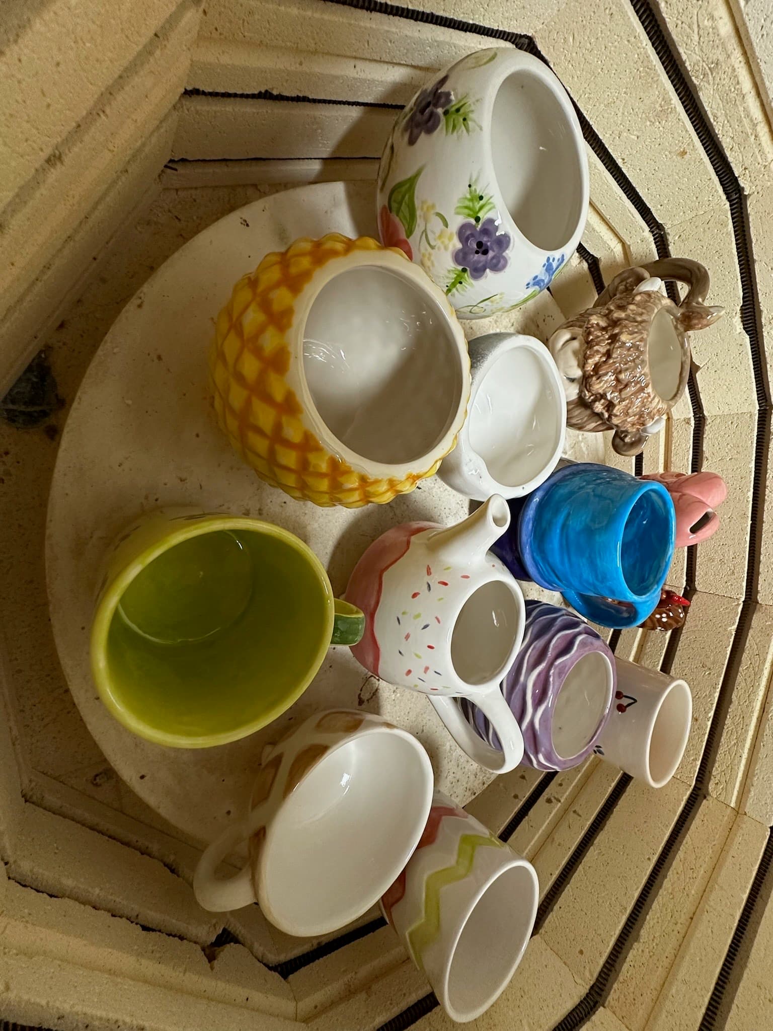Vibrant painted mugs fresh from the kiln